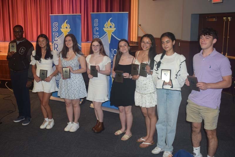 Photo of students holding certificates and plaques at East Meadow High School’s awards ceremony.