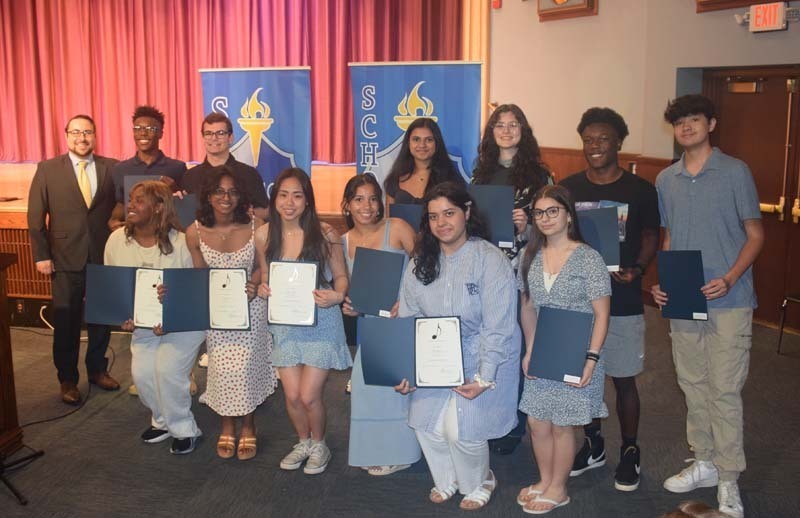 Photo of students holding certificates and plaques at East Meadow High School’s awards ceremony.