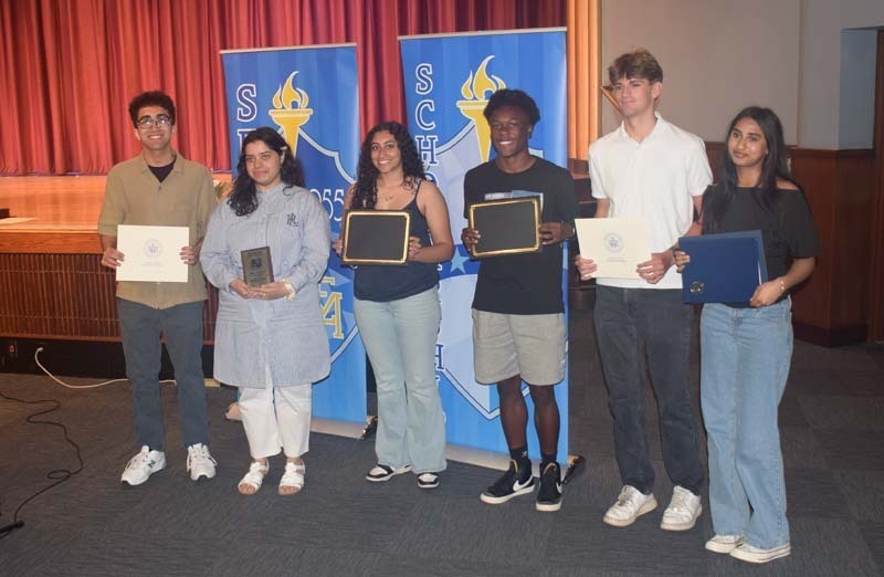 Photo of students holding certificates and plaques at East Meadow High School’s awards ceremony.