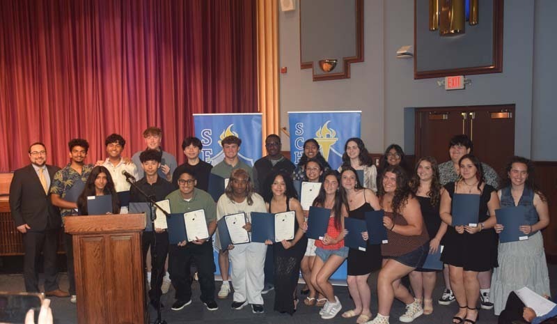 Photo of students holding certificates and plaques at East Meadow High School’s awards ceremony.