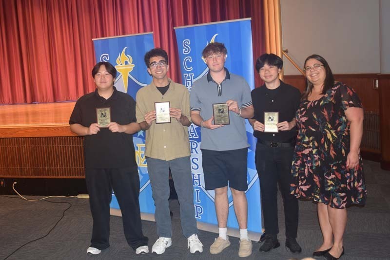 Photo of students holding certificates and plaques at East Meadow High School’s awards ceremony.