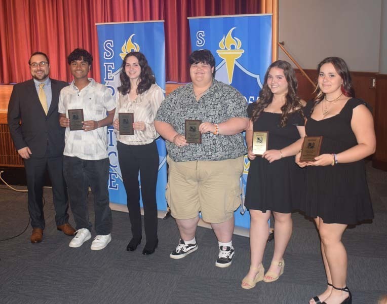 Photo of students holding certificates and plaques at East Meadow High School’s awards ceremony.