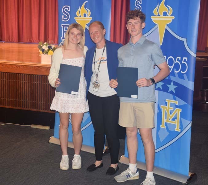 Photo of students holding certificates and plaques at East Meadow High School’s awards ceremony.