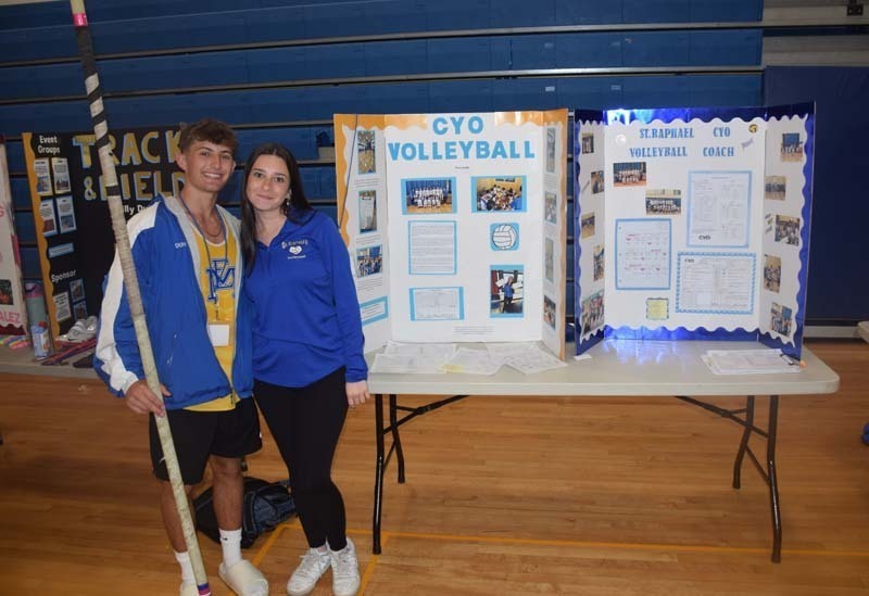 Photo of one high school student standing next to poster boards that she created depicting their future careers for their Senior Project Fair.