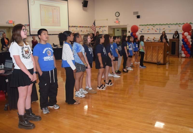 Vocalists from Barnum Woods Elementary School, under the direction of music teacher Ms. Meegan Hughes, performed the Star-Spangled Banner at the start of the meeting. 