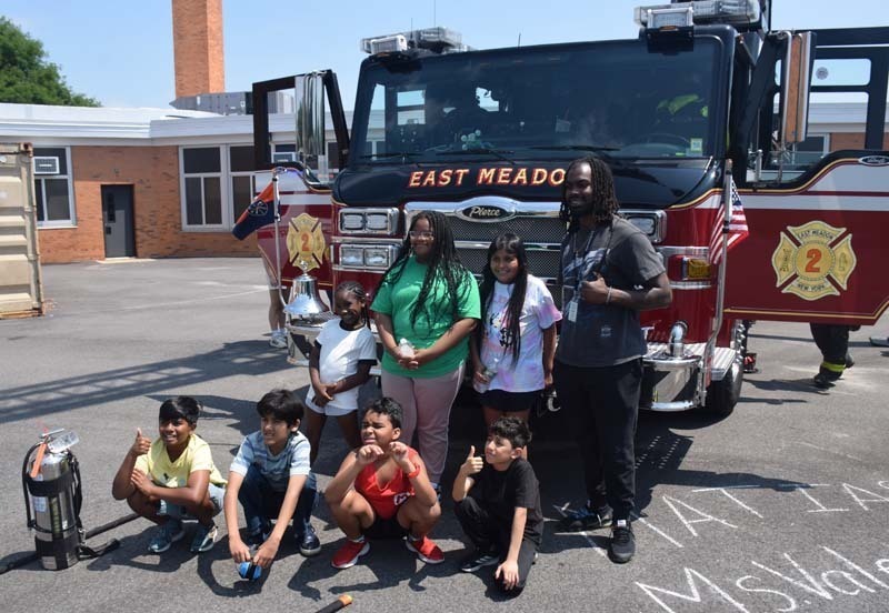 Firefighter talking to students outside.