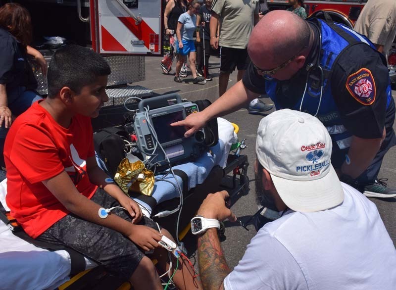 Student receiving demonstration from fireman.