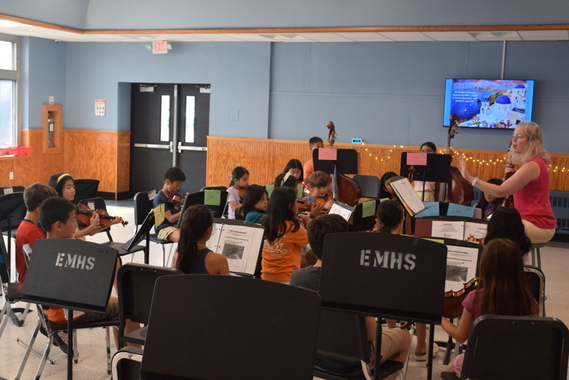 orchestra practice with conductor and students