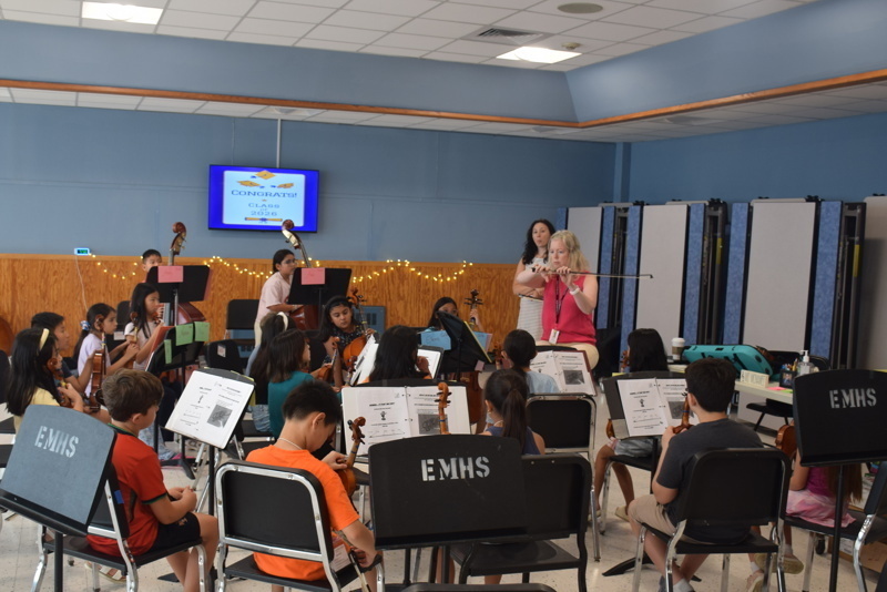 orchestra practice with conductor and students