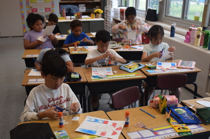 Students crafting at desks in classroom