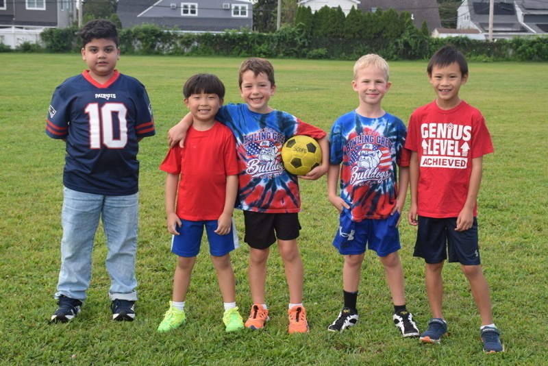 Children posing on grassy field