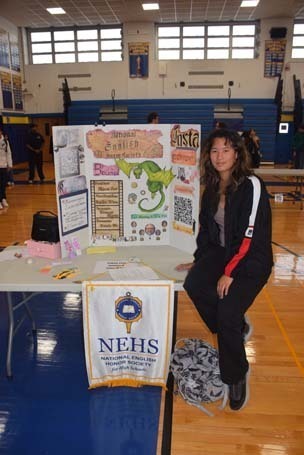 Photo of high school students with posterboard of their club.