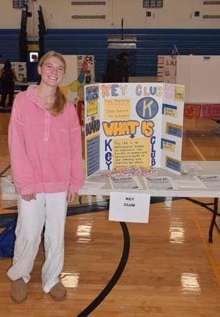 Photo of high school students with posterboard of their club.