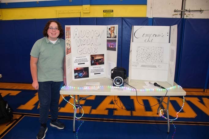Photo of high school students with posterboard of their club.