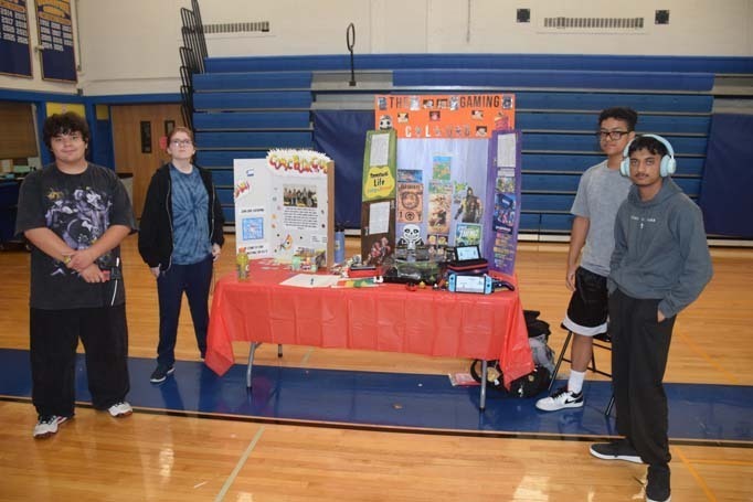 Photo of high school students with posterboard of their club.