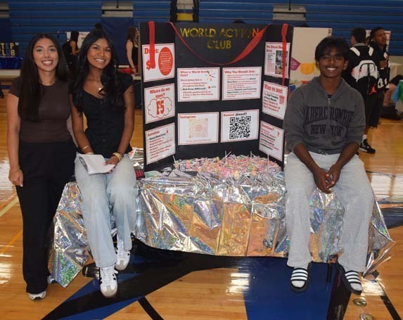 Photo of high school students with posterboard of their club.