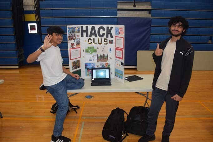 Photo of high school students with posterboard of their club.