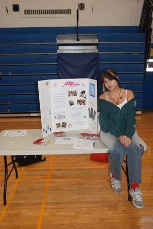 Photo of high school students with posterboard of their club.