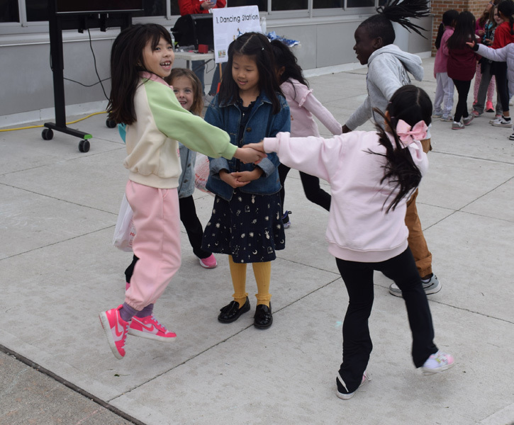 students hold hands and are dancing