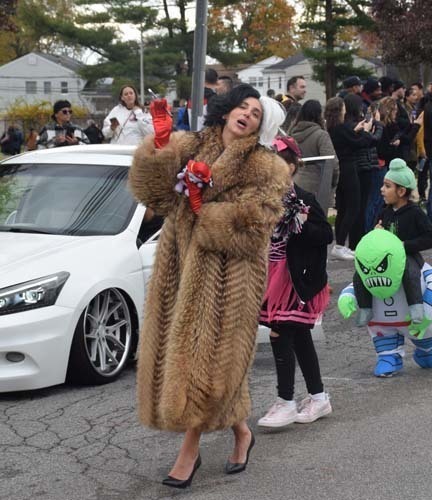 Students marching on the street while wearing Halloween costumes.