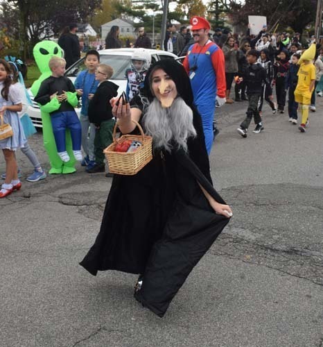 Students marching on the street while wearing Halloween costumes.