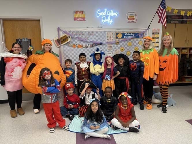 SStudents marching on the street while wearing Halloween costumes.
