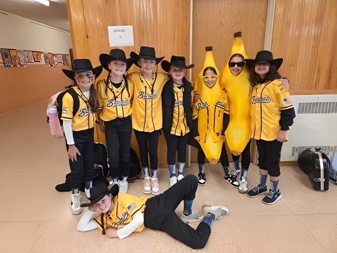 SStudents marching on the street while wearing Halloween costumes.
