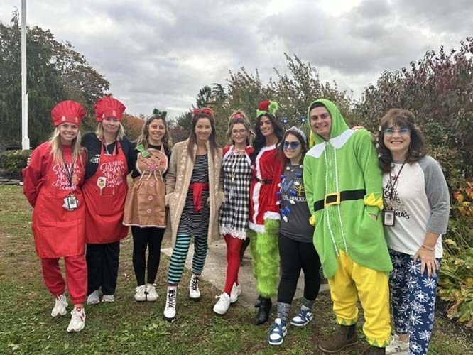 Students marching on the street while wearing Halloween costumes.