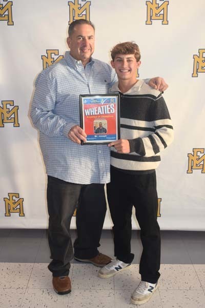 Photo of student and faculty member holding Breakfast of Champions plaque.