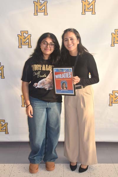 Photo of student and faculty member holding Breakfast of Champions plaque.