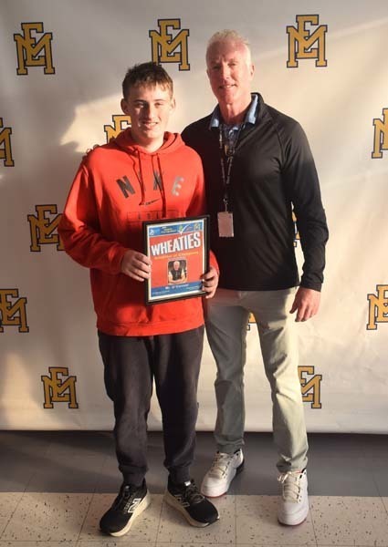 Photo of student and faculty member holding Breakfast of Champions plaque.