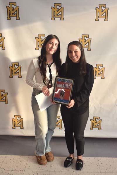 Photo of student and faculty member holding Breakfast of Champions plaque.