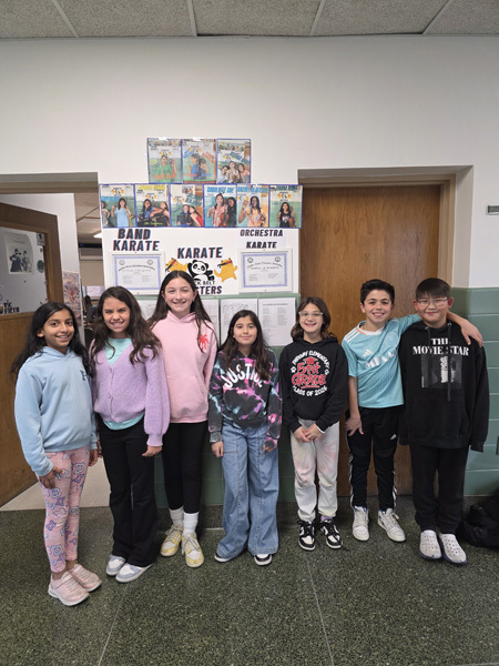 group of smiling children stand in a school hallway