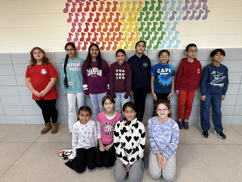 group of smiling children stand in a school hallway