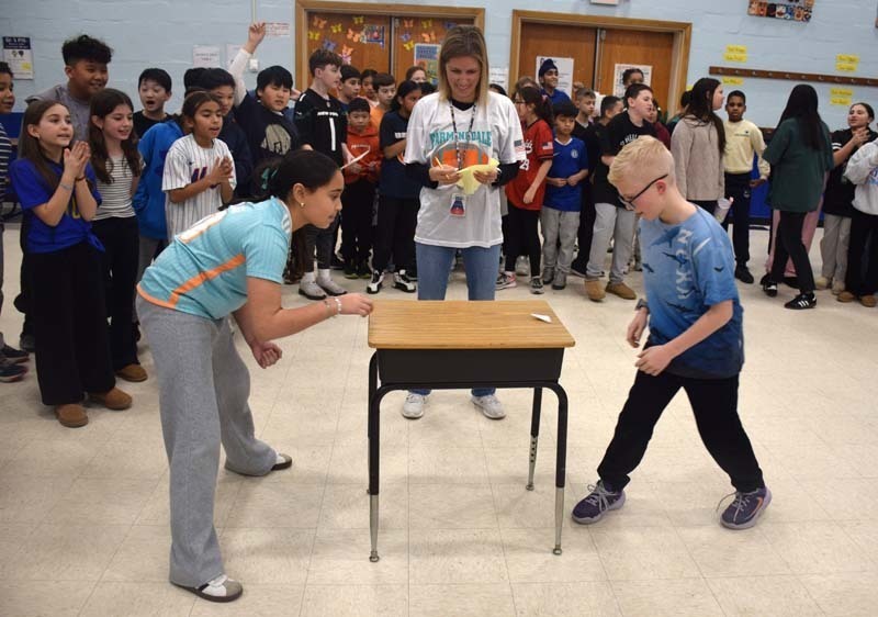 Students playing paper football.