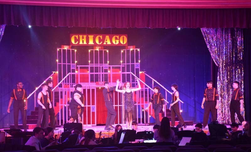 Photo of students and pit crew performing with a sign at the top that reads Chicago.