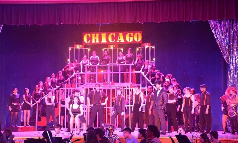 Photo of students and pit crew performing with a sign at the top that reads Chicago.