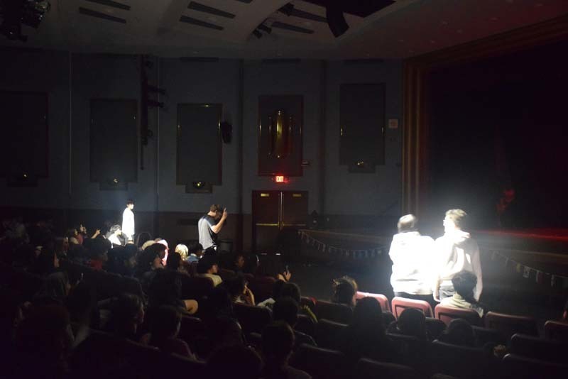 Photo of students wearing traditional, colorful dresses from their home country while dancing.