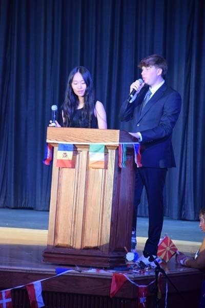 Photo of students wearing traditional, colorful dresses from their home country while dancing.