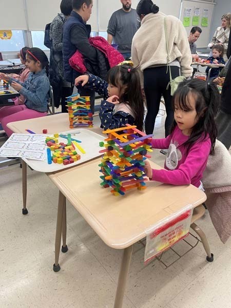 Two students stacking materials on their desks Two students stacking materials on their desks