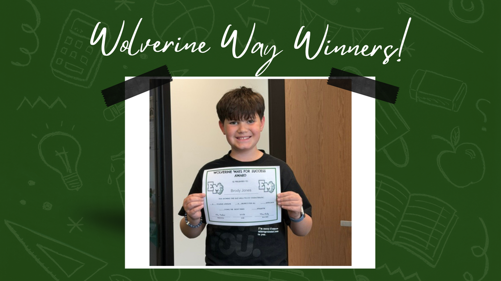 Young boy smiling and holding a Wolverine Way certificate