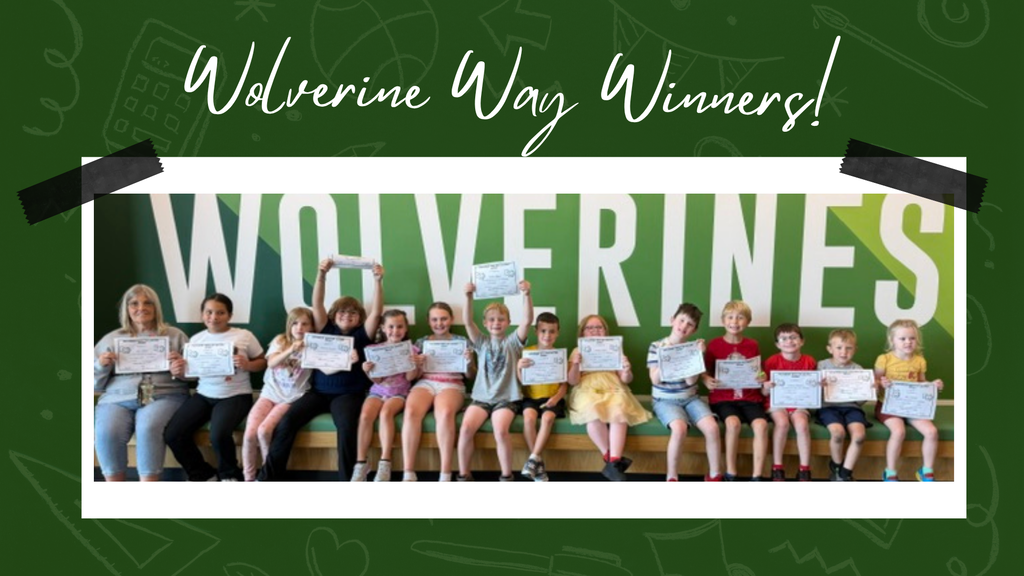 Students smiling in front of a "wolverine" sign, holding their certificates