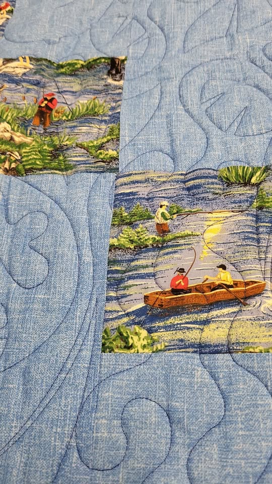 Quilt stitching of a boat in a pond