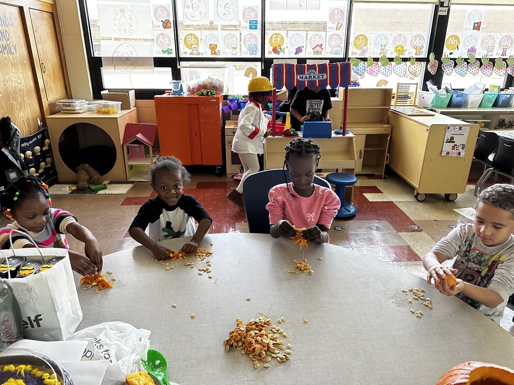 Kindergarten students in Mrs. Farren’s class explore the inside of pumpkins, scooping out seeds and pulp during a hands-on fall learning activity.