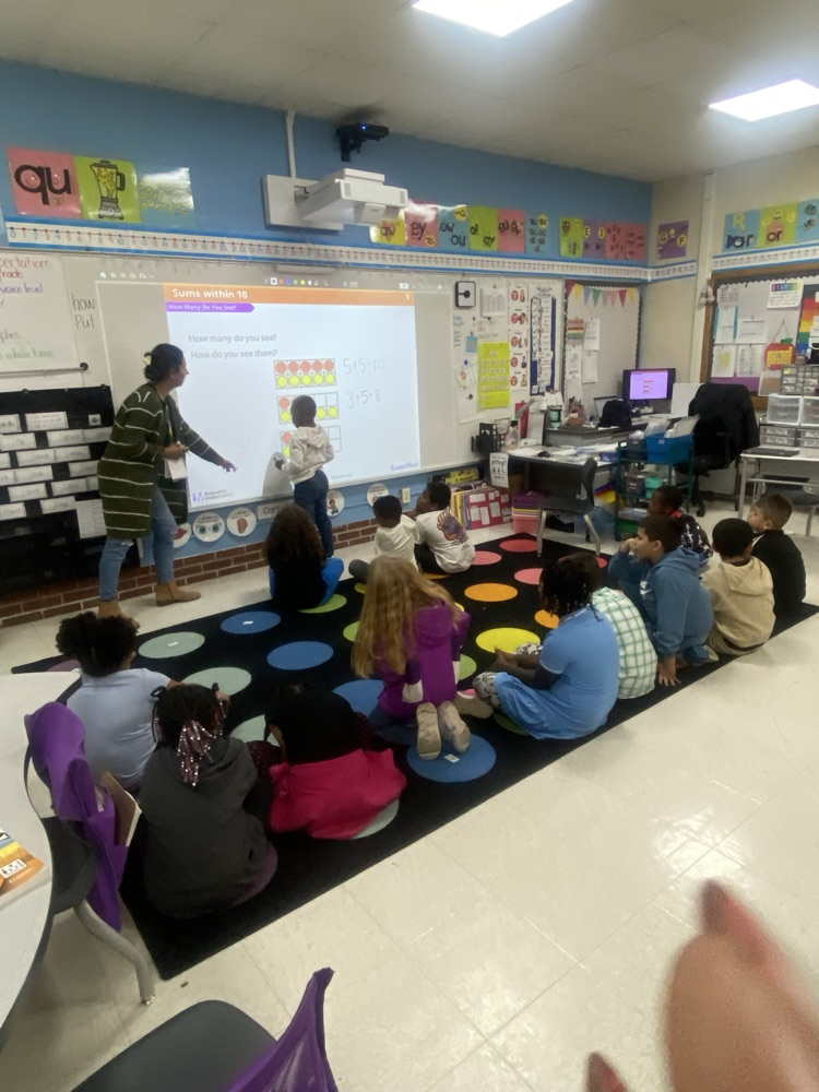 A student working out math equations on the board.