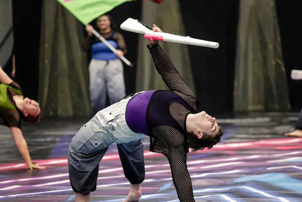 winter guard member throwing prop rifle