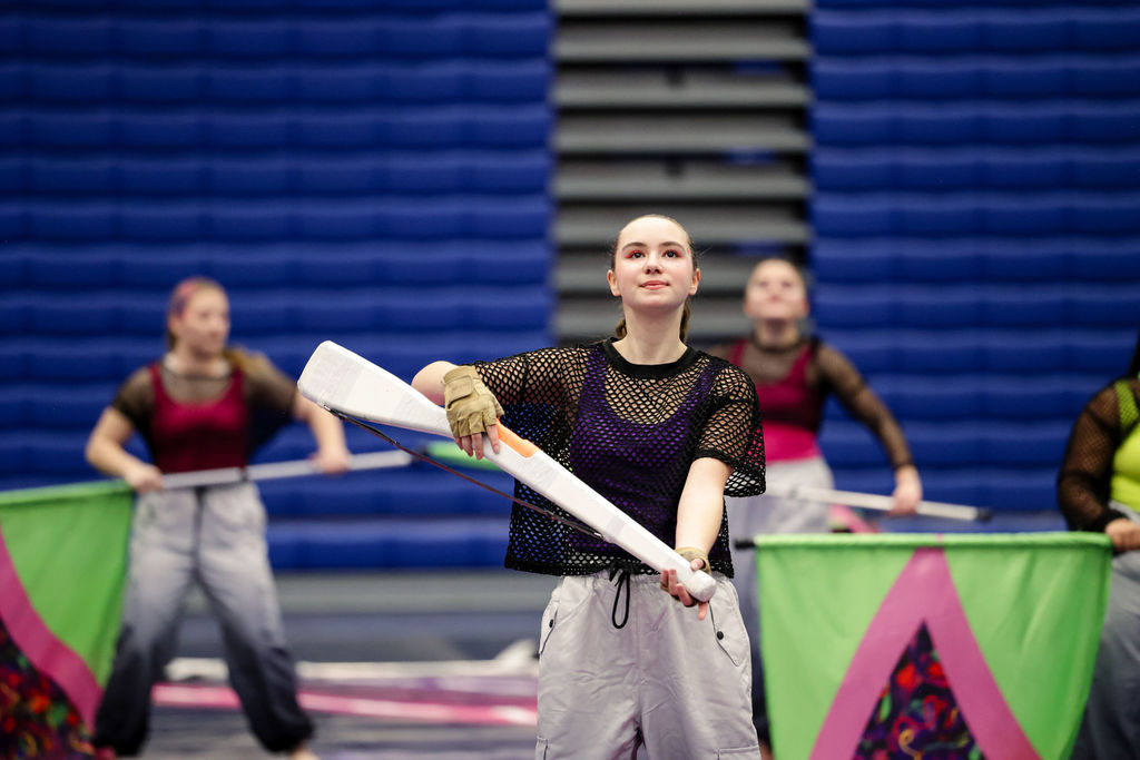 winter guard member throwing prop rifle