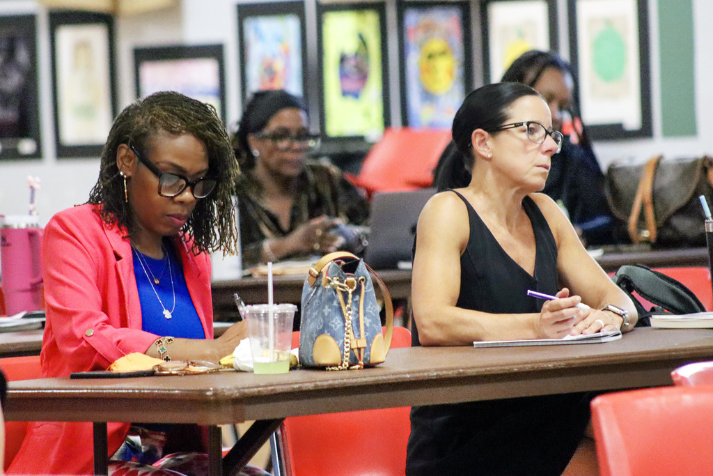 image of twon women paying attend with hands on desk