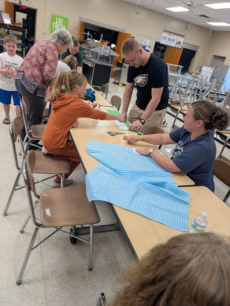 students and adults sewing