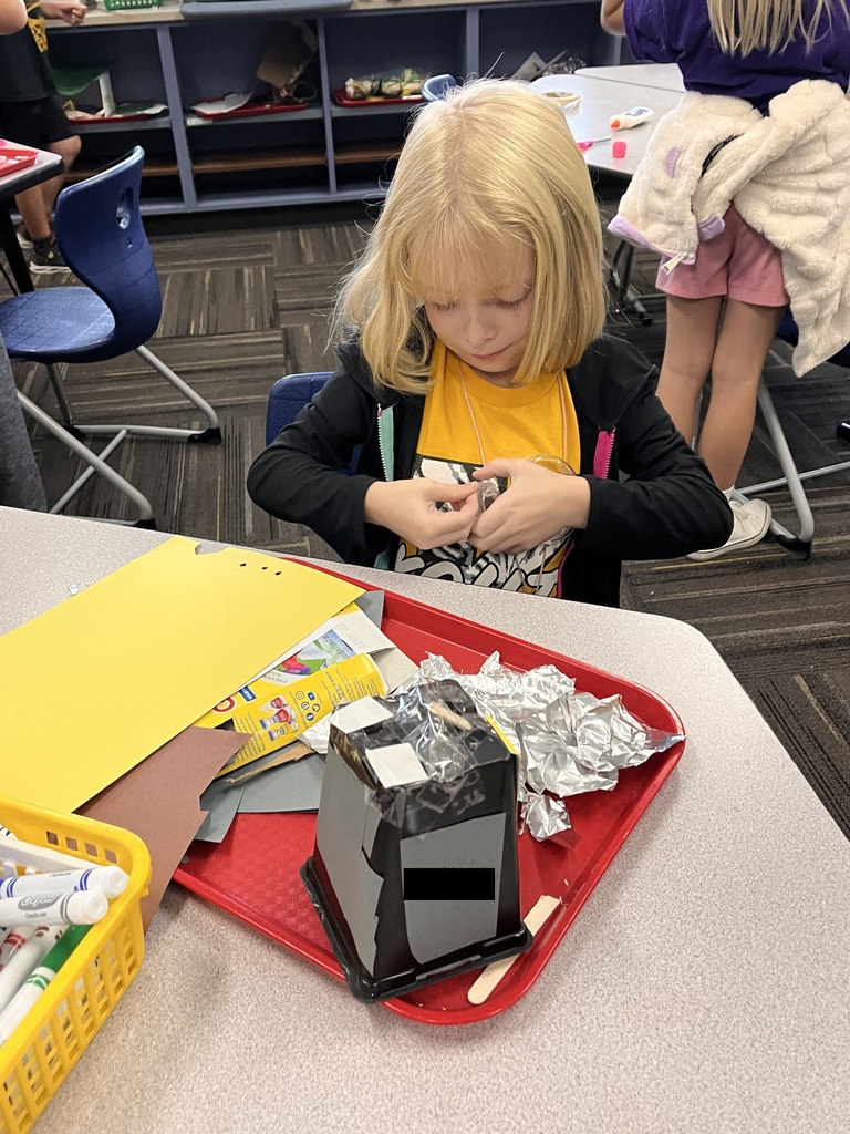 Student desigining a structure with class supplies